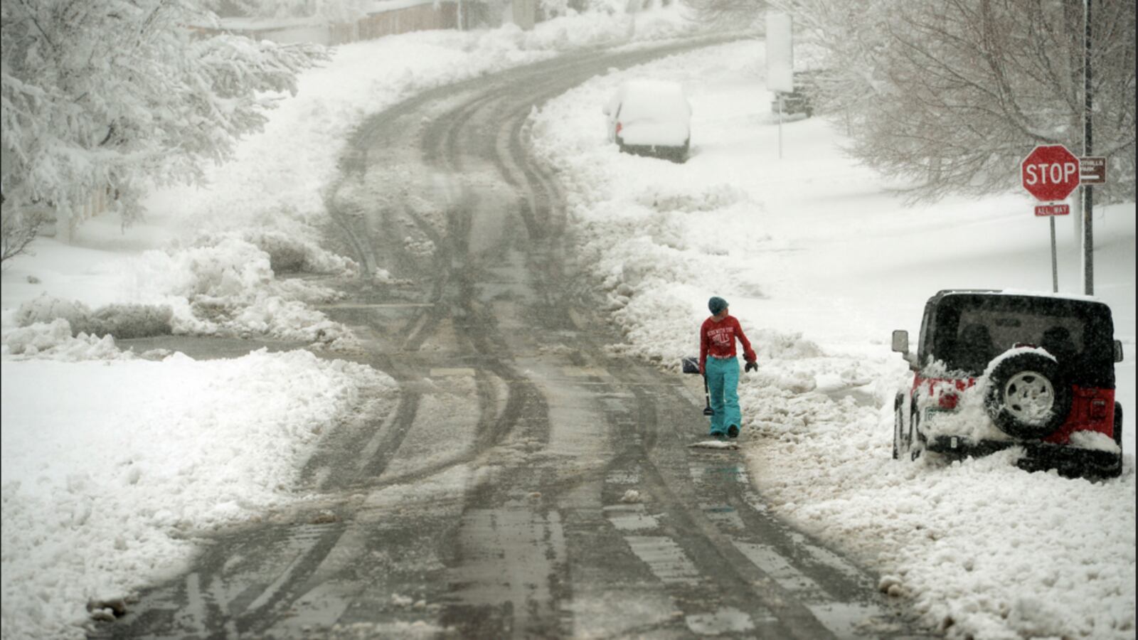 A young snow shoveler walks the street looking to shovel sidewalks after an overnight blizzard dumped snow in the Indigo Hills subdivision March 23, 2016 in Highlands Ranch.