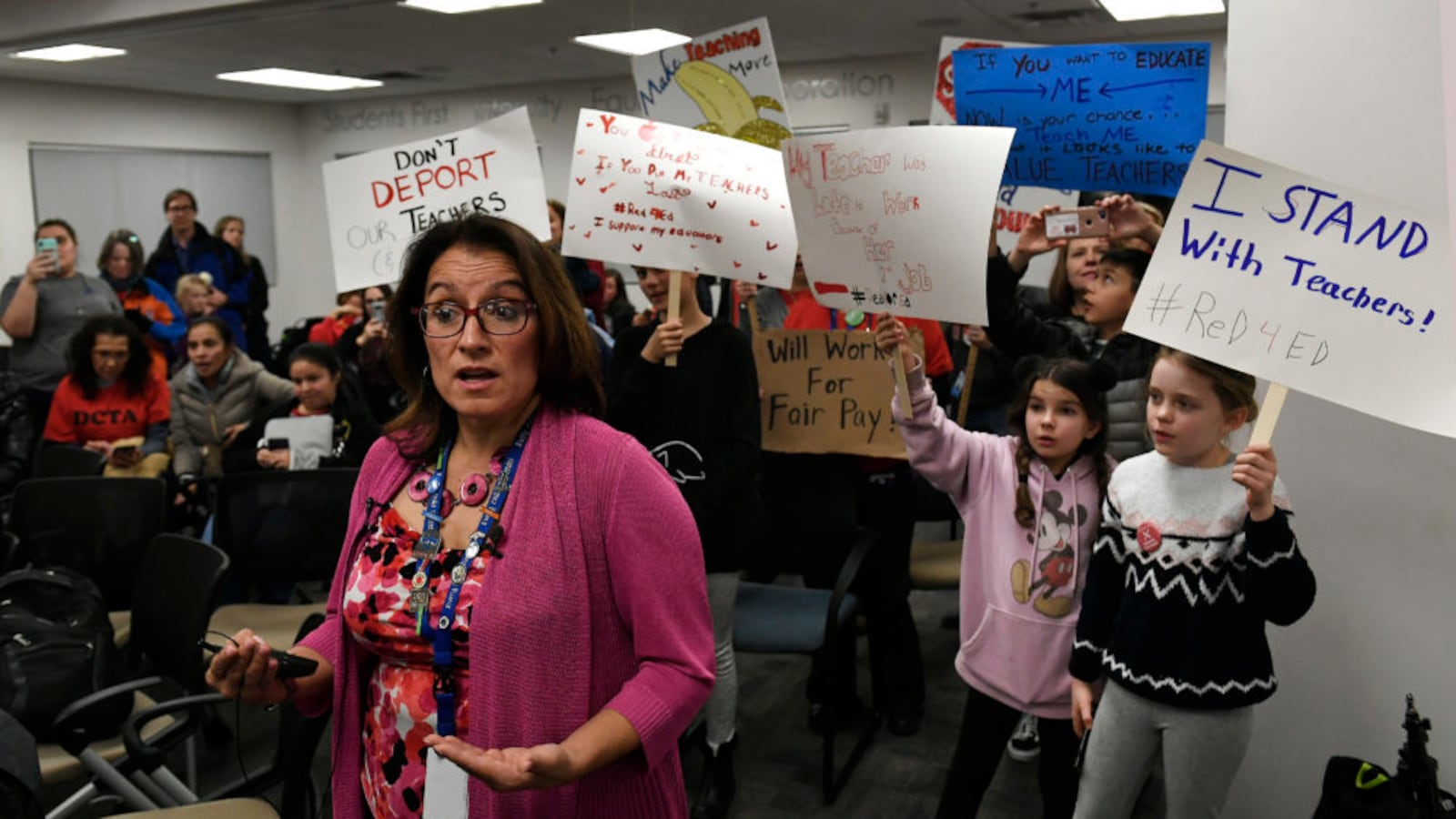 Denver Superintendent Susana Cordova answers questions for the media as students hold up signs behind her after teachers rejected the district's latest proposal.