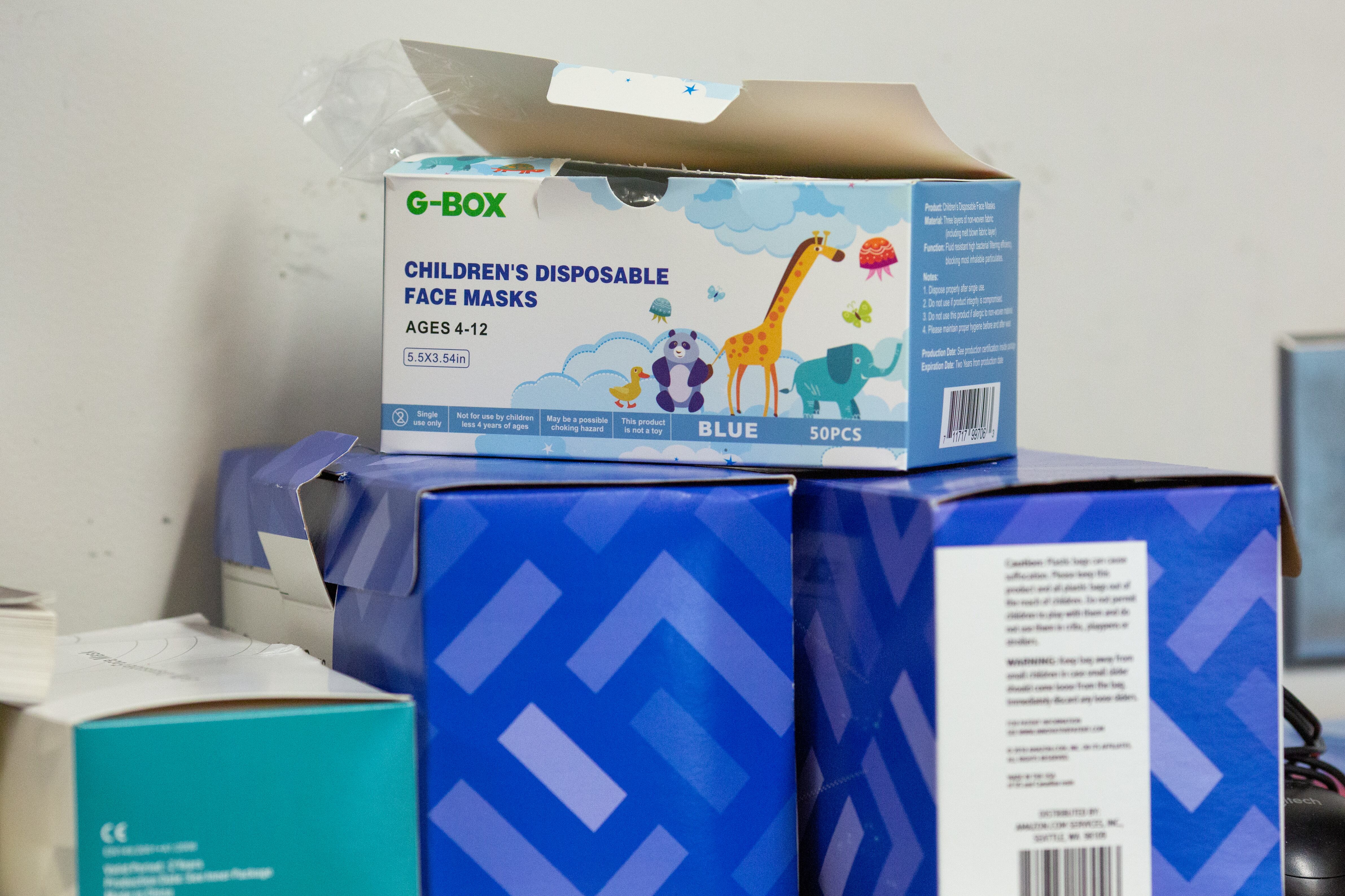 Disposable masks sit on a shelf in a fifth grade class.