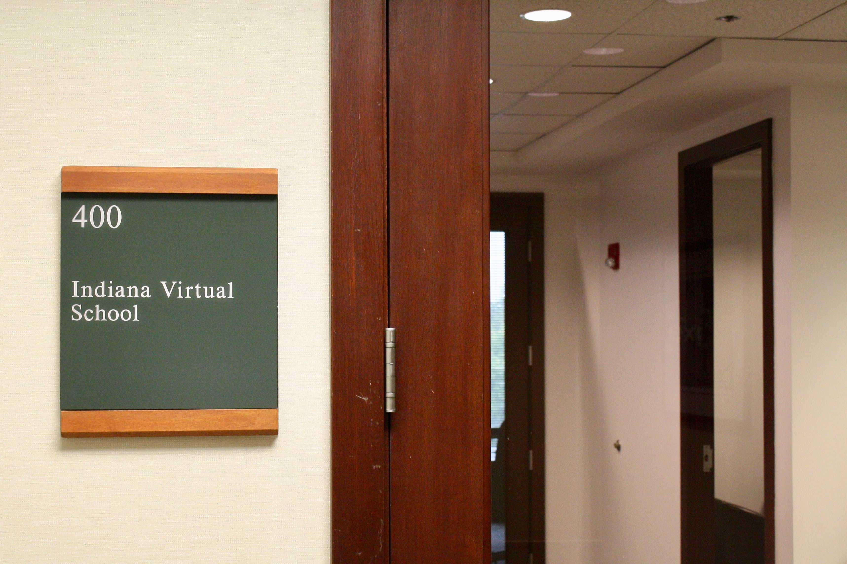 A small office sign that reads "Indiana Virtual School" is next to a door with a glass front.