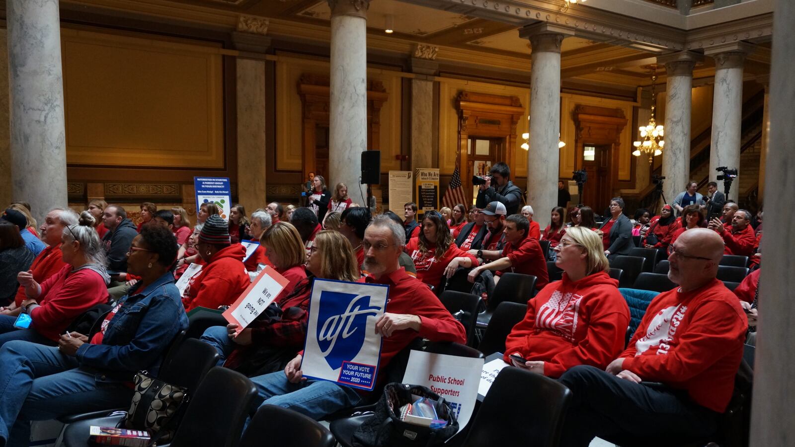 About 100 people gathered for a rally at the Indiana Statehouse in support of increasing funding for traditional public schools.