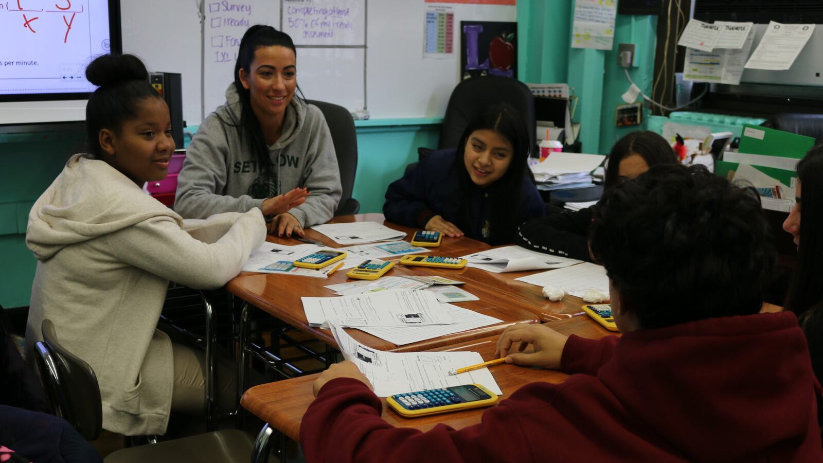 An eighth-grade math teacher discusses a problem with students at I.S. 96 and encourages a student who is learning English as a new language to explain his answer. Roughly half of his peers are also learning the language.