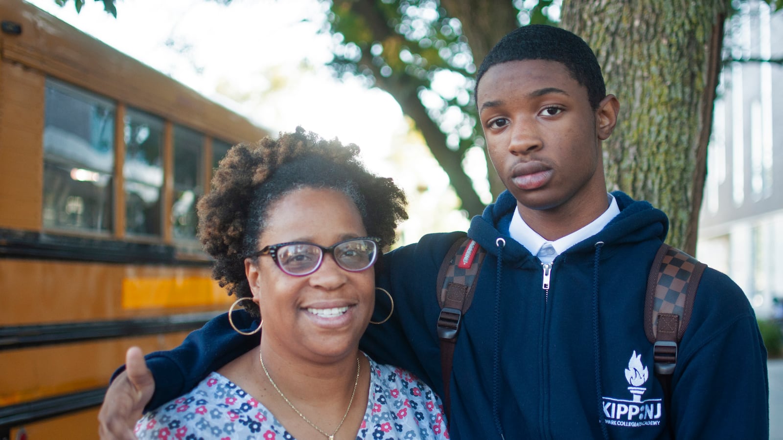 Van Ness Roper's wife, Patricia Noon-Roper, stands with her son, Jahad Noon-Glanton, in front of the KIPP charter school he now attends. Jahad's parents moved him to a charter school after his district school didn't provide him with the services that he requires to accommodate his learning disability.