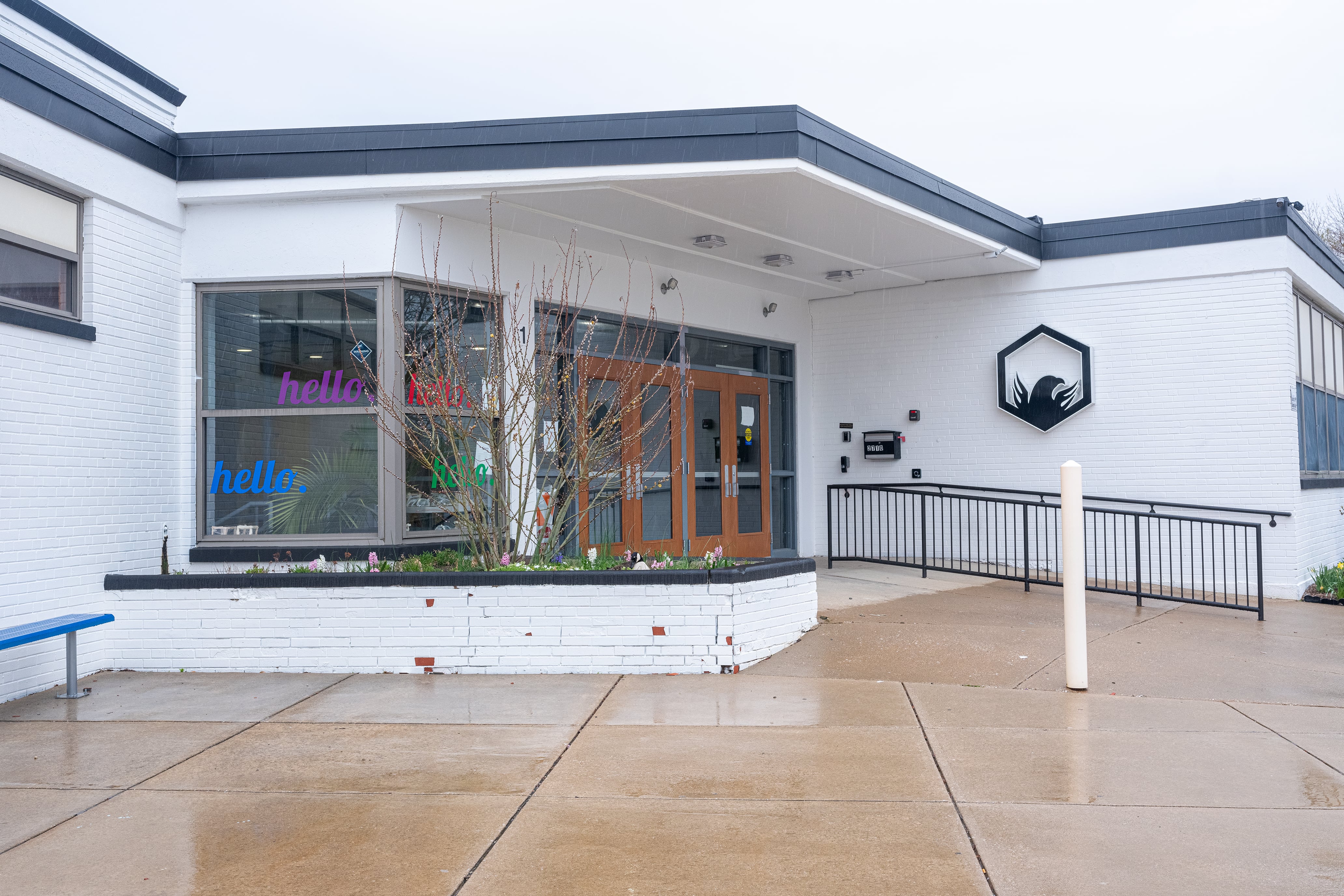 A white and blue school building outside on a rainy day.