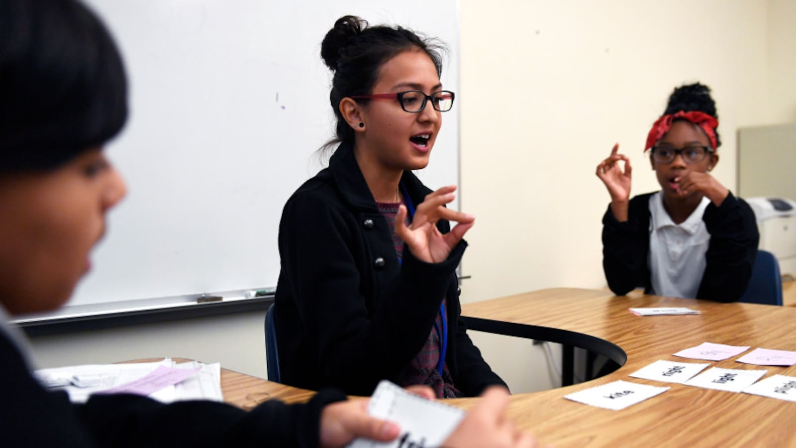 Paraprofessional Sonia Guzman a student from the University of Northern Colorado's Urban Education Program tapping out the sounds of each word during a 2017 class at Elkhart Elementary school in Aurora. The program tries to get graduates from Denver and Aurora schools to come back to their old schools to be teachers.
