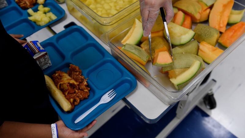 Vanessa Briones serves fruit to first graders during lunch at Laredo Elementary School on August 16, 2017, in Aurora, Colorado.