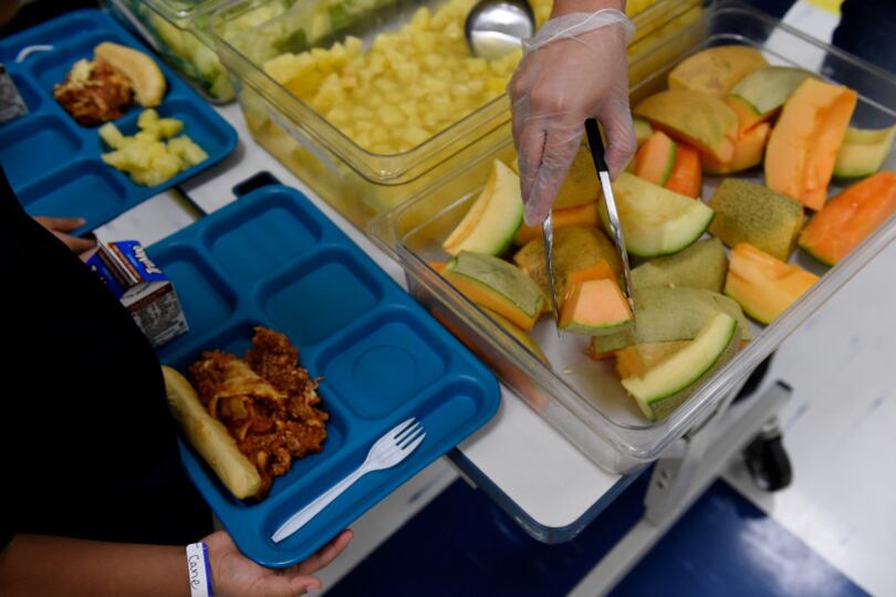 Vanessa Briones serves fruit to first graders during lunch at Laredo Elementary School on August 16, 2017, in Aurora, Colorado.