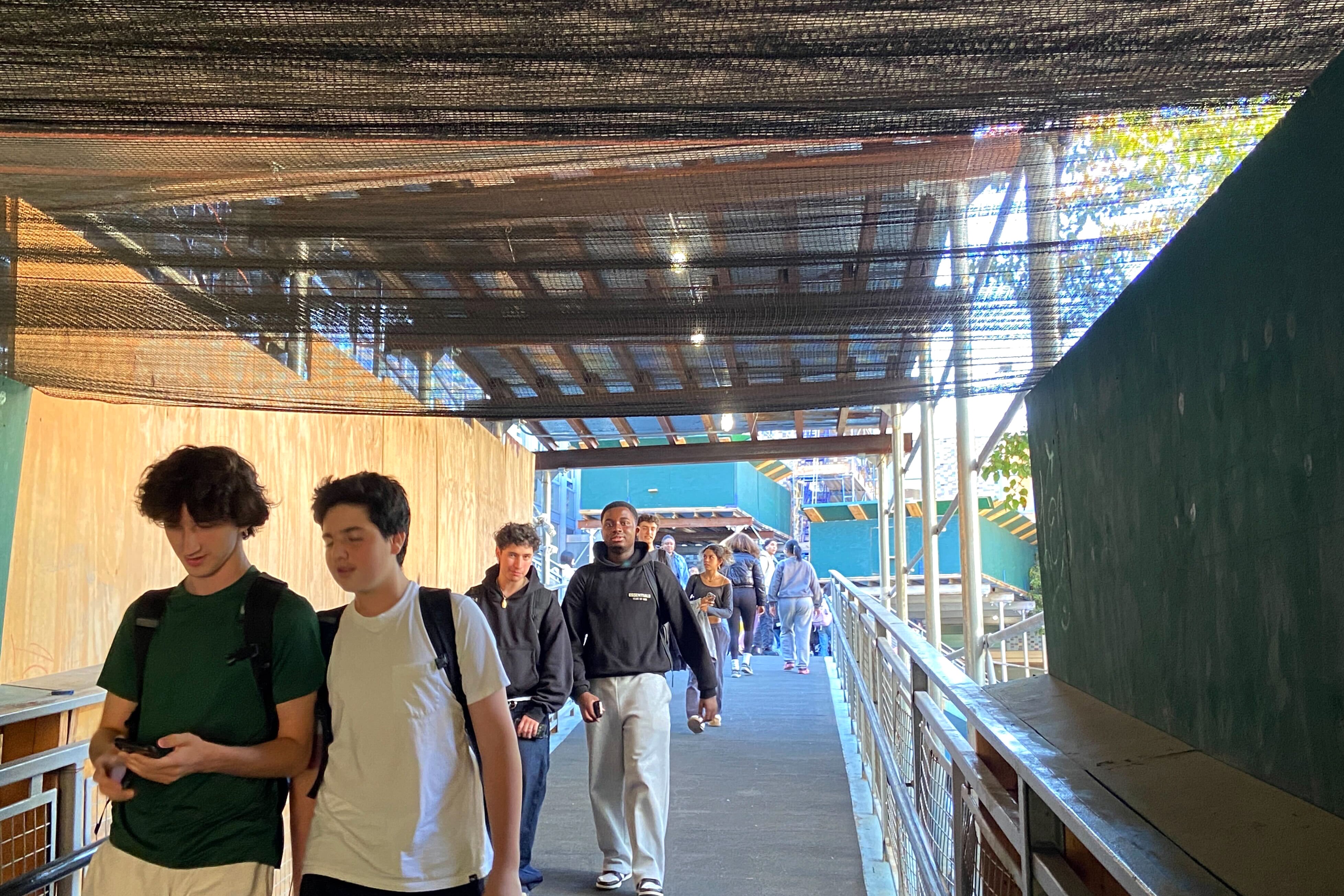 A group of students walk through construction.