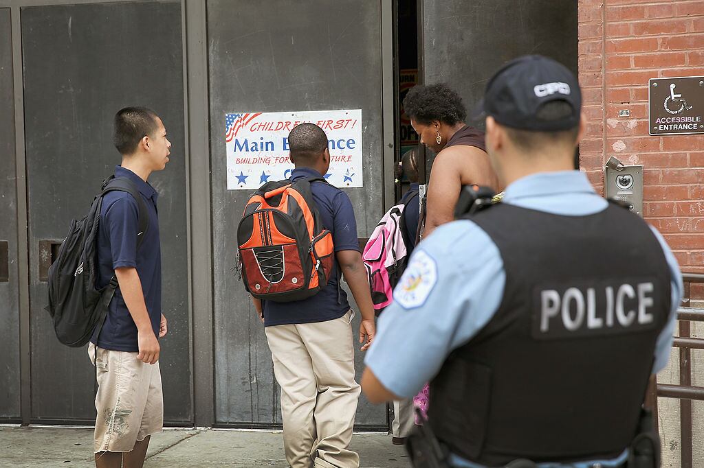 A police officer watched as students arrive to Laura Ward Elementary School on the West Side.