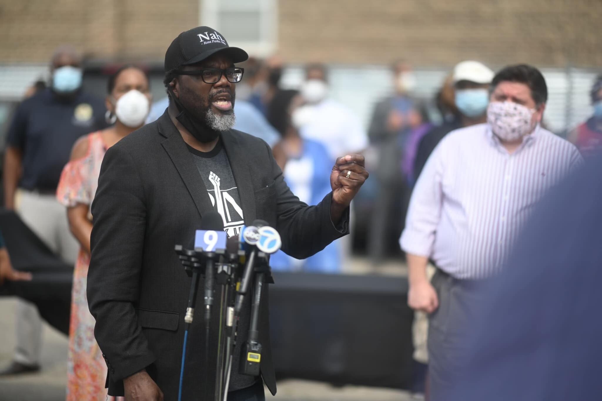 A man speaks in front of microphones.