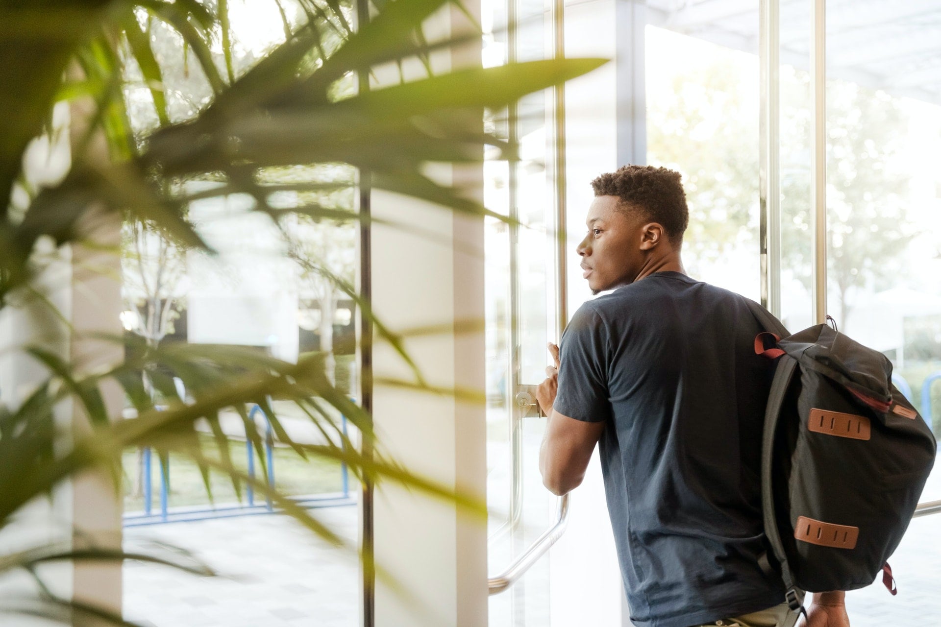 Student wearing a backpack exiting a building.