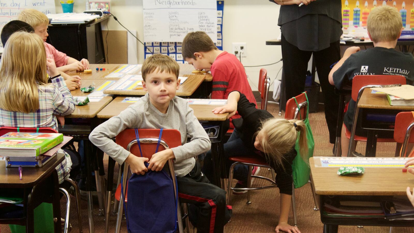 Elementary school students work begin work on an English assignment while enjoying a mid-morning snack.
