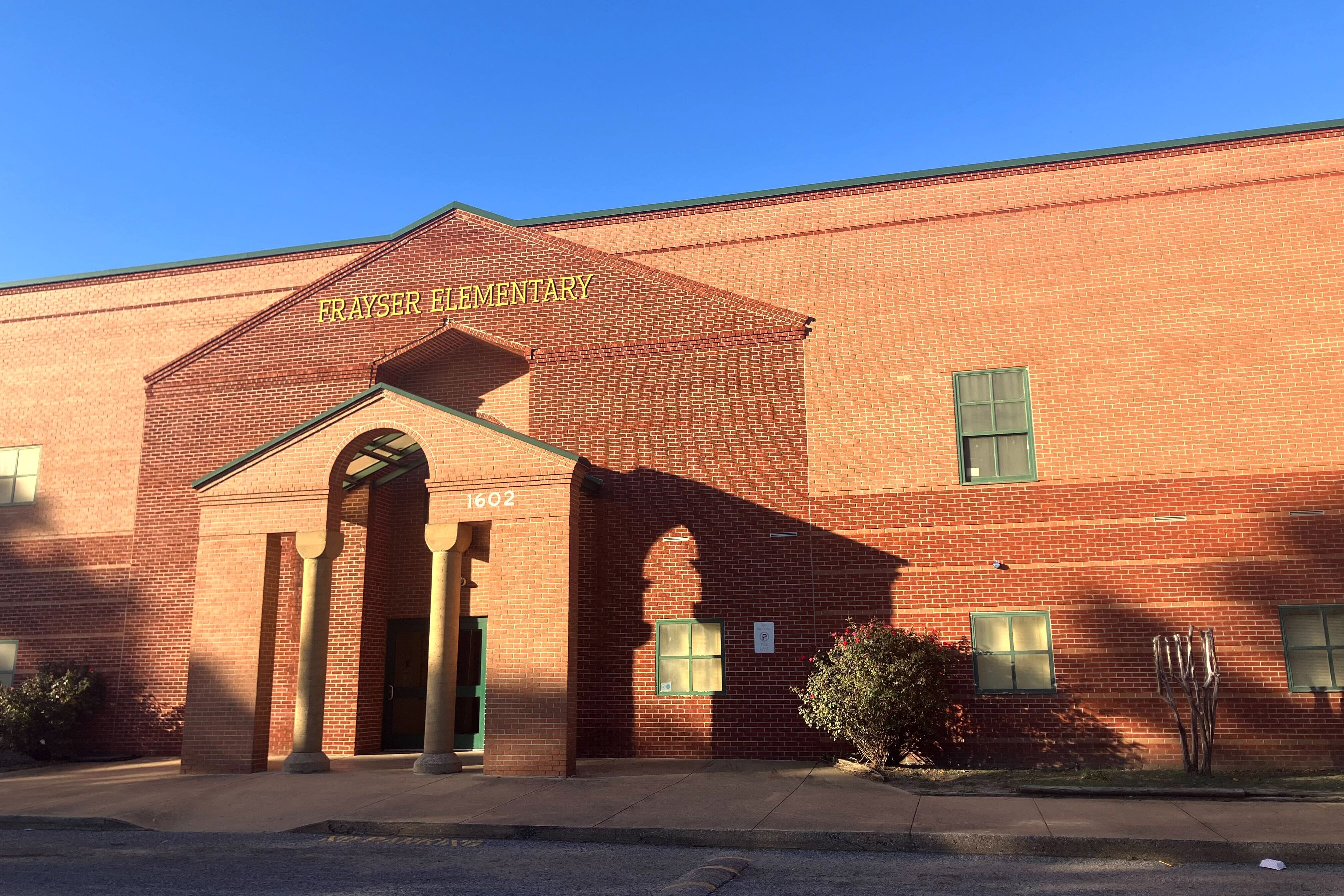 Sun casts shadows on a brick building.