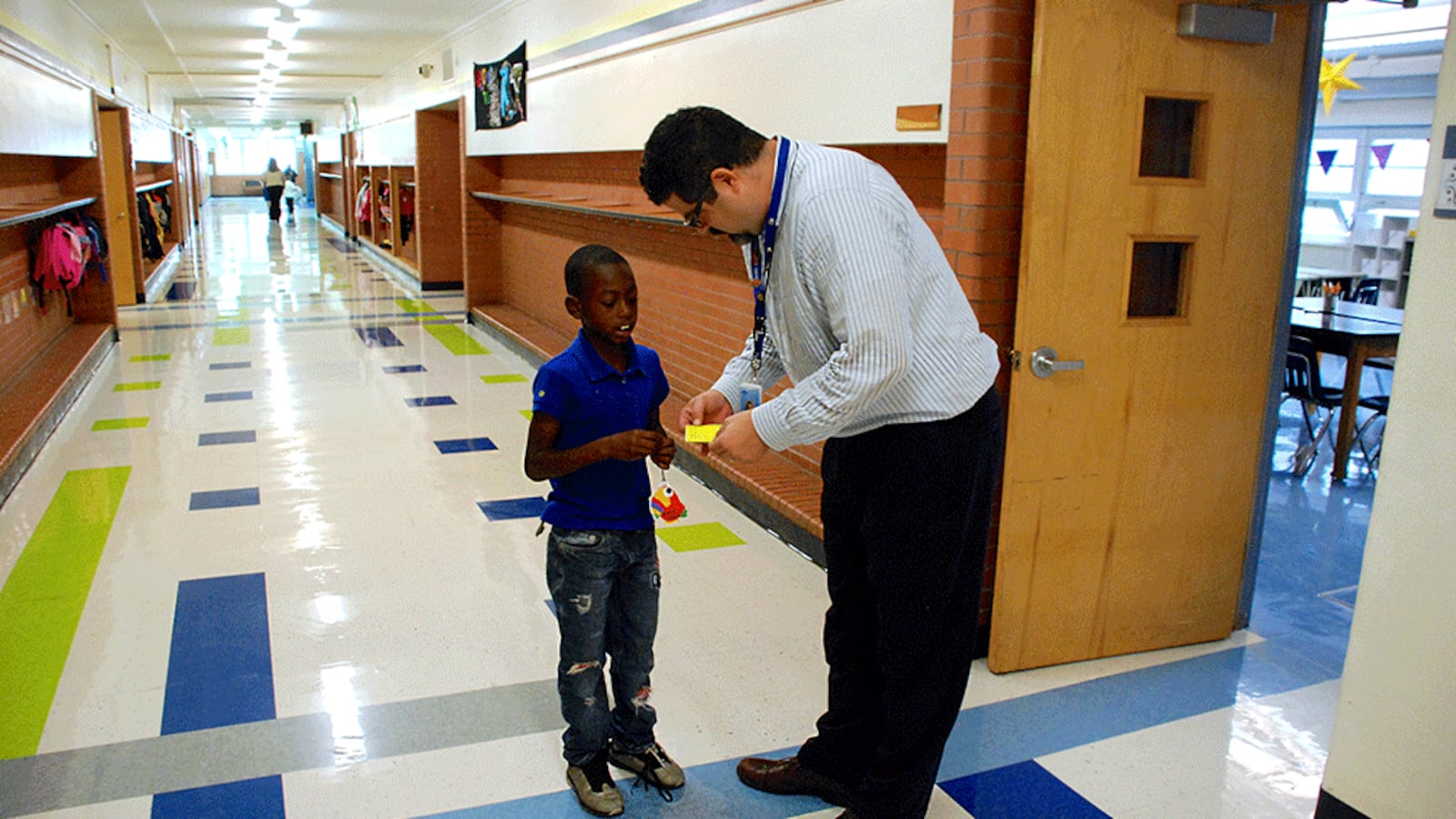Columbine Elementary School principal Jason Krause looks at a student's hall pass. Krause is Columbine's latest principal, the school's fifth in seven years.