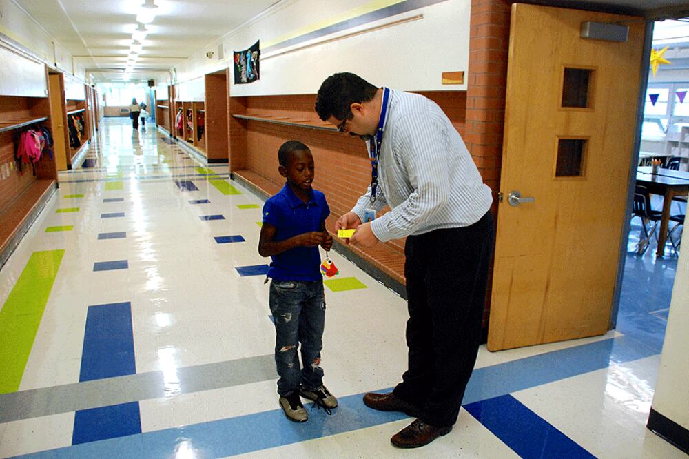 Columbine Elementary School principal Jason Krause looks at a student's hall pass. Krause is Columbine's latest principal, the school's fifth in seven years.