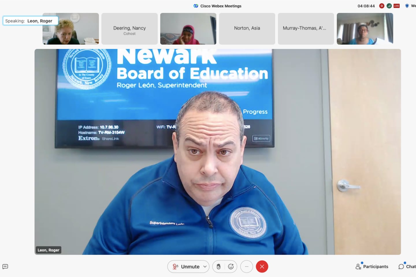 A man wearing a blue shirt appears on a Newark Board of Education Zoom video call with other members. 
