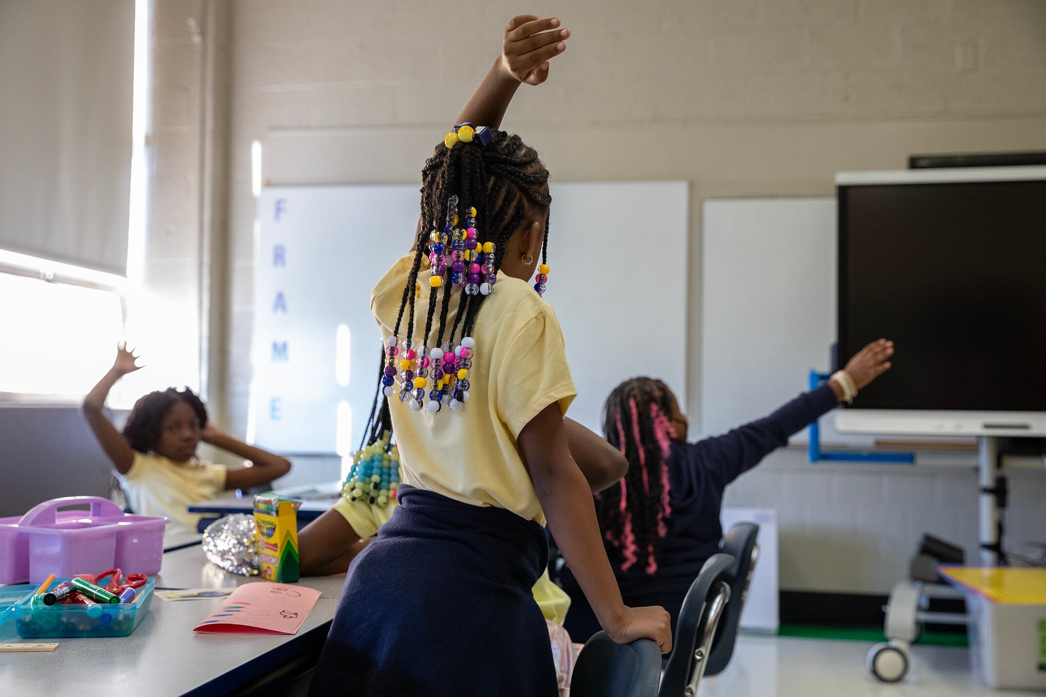 Students raise their hands to answer a question.