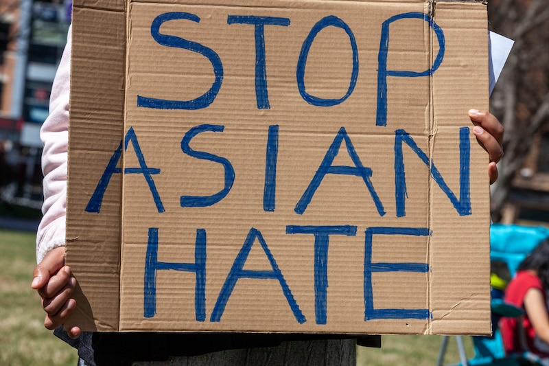 A protester holds a placard against Asian violence during