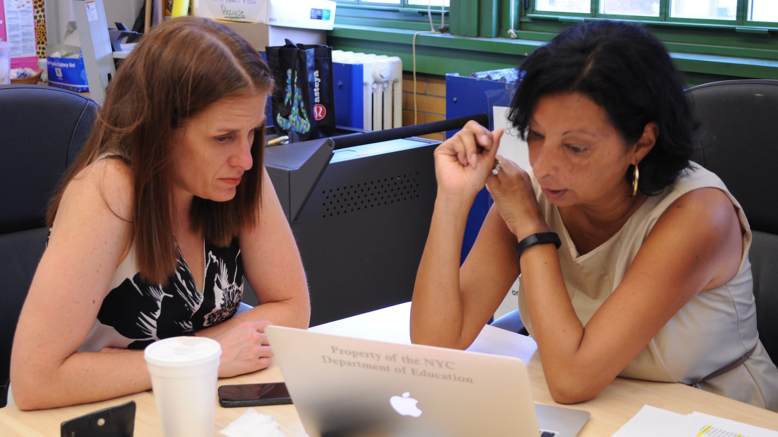 Devon Eisenberg, left, looks over graduation ceremony plans with co-director LeMarie Laureano at the Young Women's Leadership School in the Bronx.