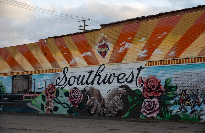 A colorful mural that reads "Southwest" on the side of a brick building.