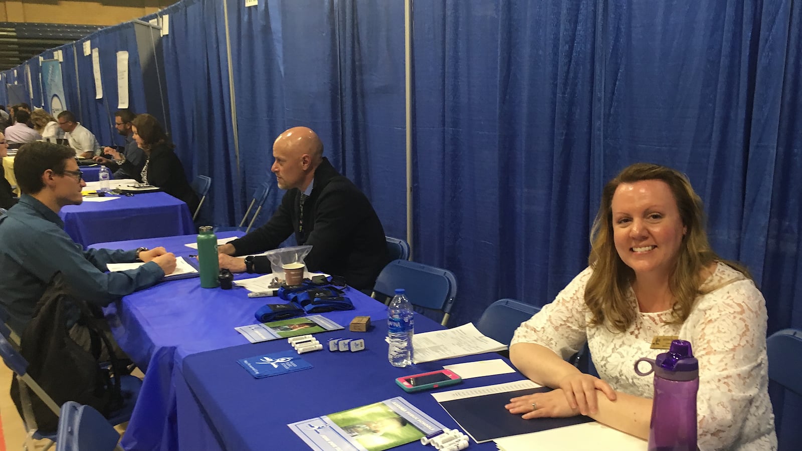 A recruiter from Aurora Public Schools works a booth at a job fair at the University of Northern Colorado.