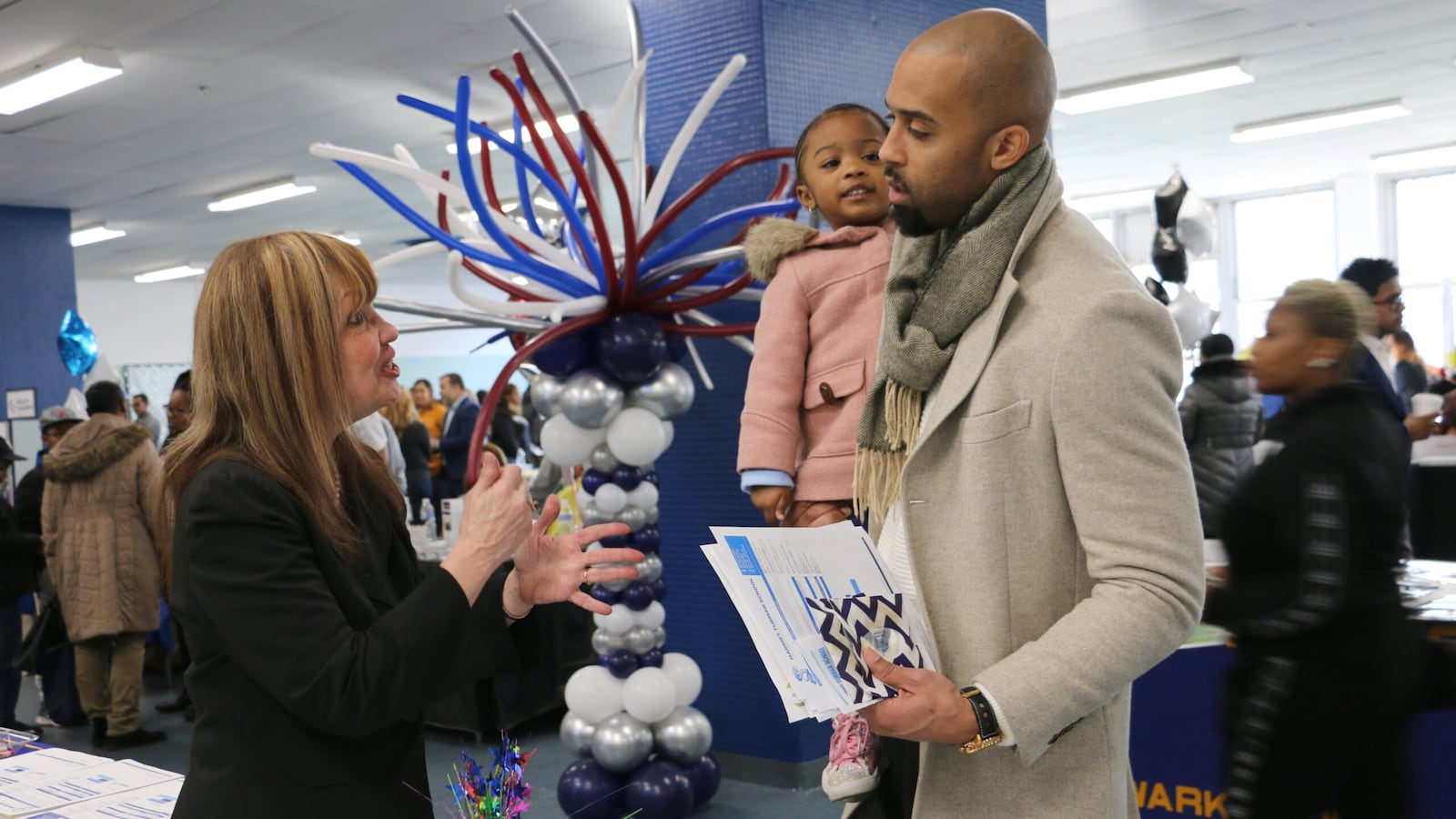 A parent at Newark's citywide school fair in 2018. Families will have to wait several more weeks to learn what schools their children will attend this fall.