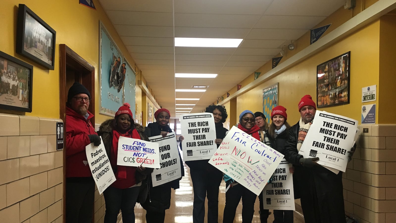 Teachers and union members at CICS Wrightwood stand with protest signs.