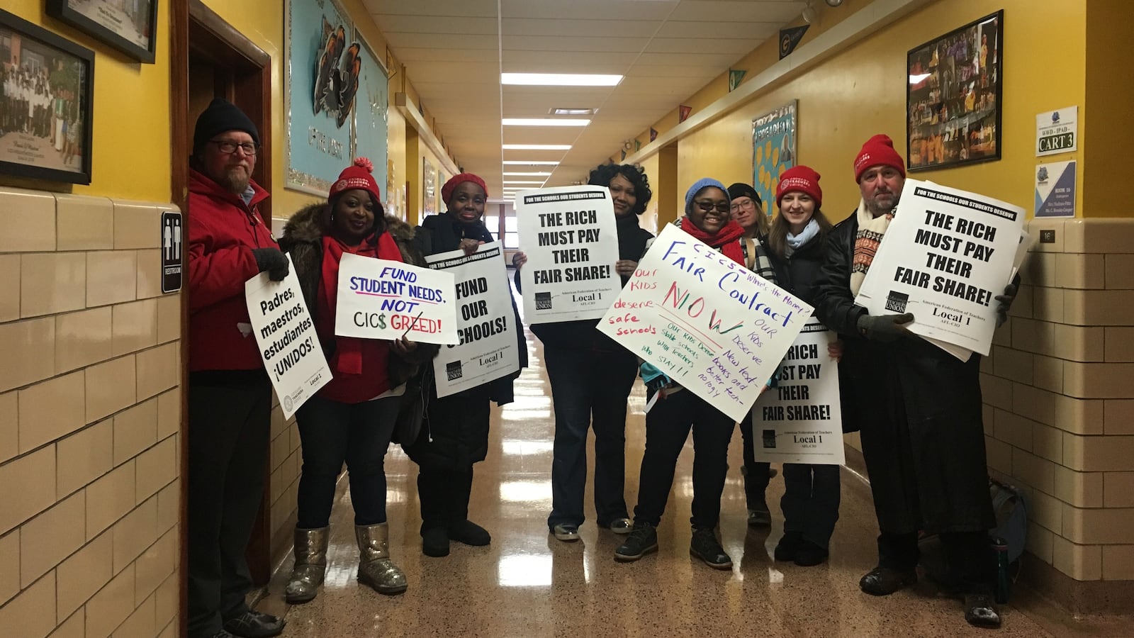Teachers and union members at CICS Wrightwood stand with protest signs.