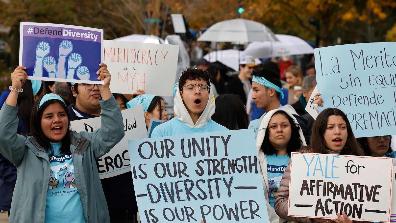 A group of students are standing at a rally, carrying signs supporting affirmative action.
