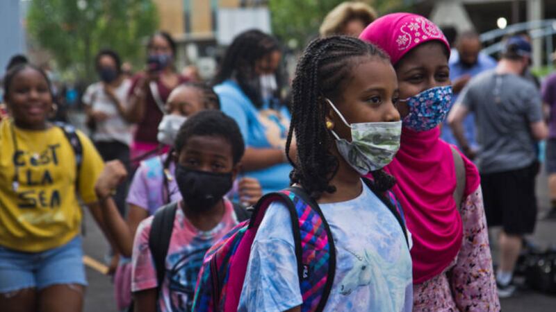 Philadelphia students, wearing protective masks, arrive for the first day of classes.