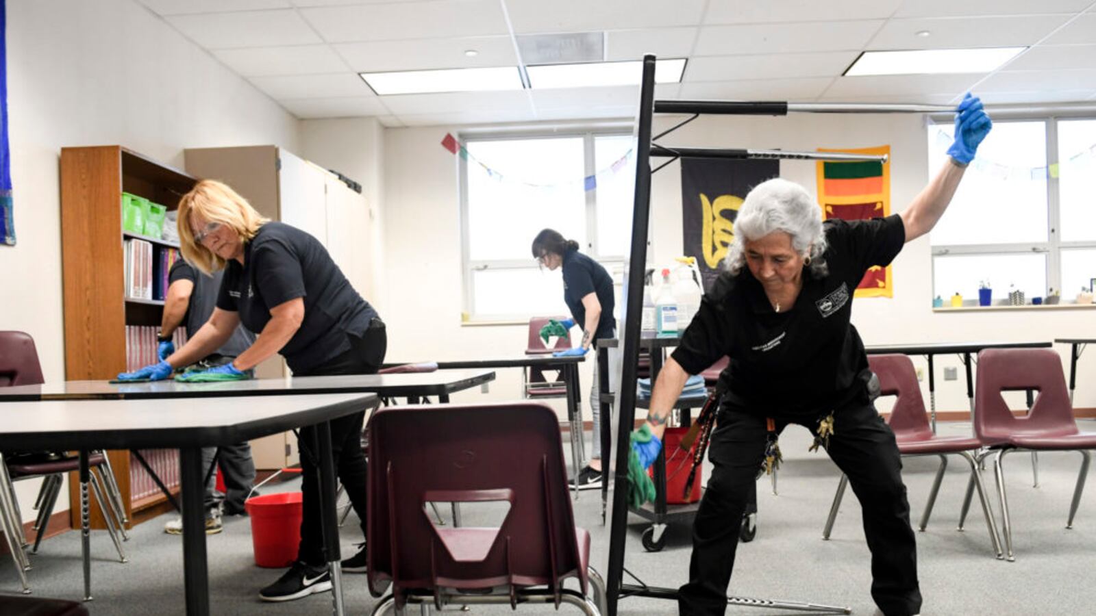 From left to right Jose Garcia, Mary Garibay, Shelby Gallegos and Lenora Vallejos clean a classroom at Bruce Randolph School in Denver on Thursday, March 19, 2020.