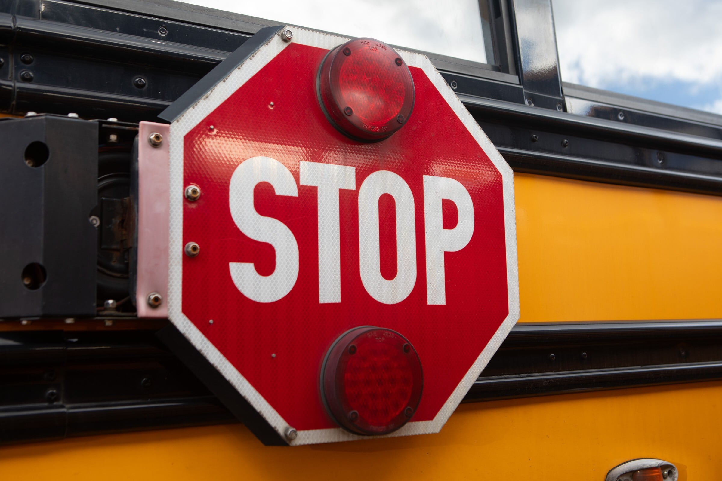 A stop sign on the side of a school bus.