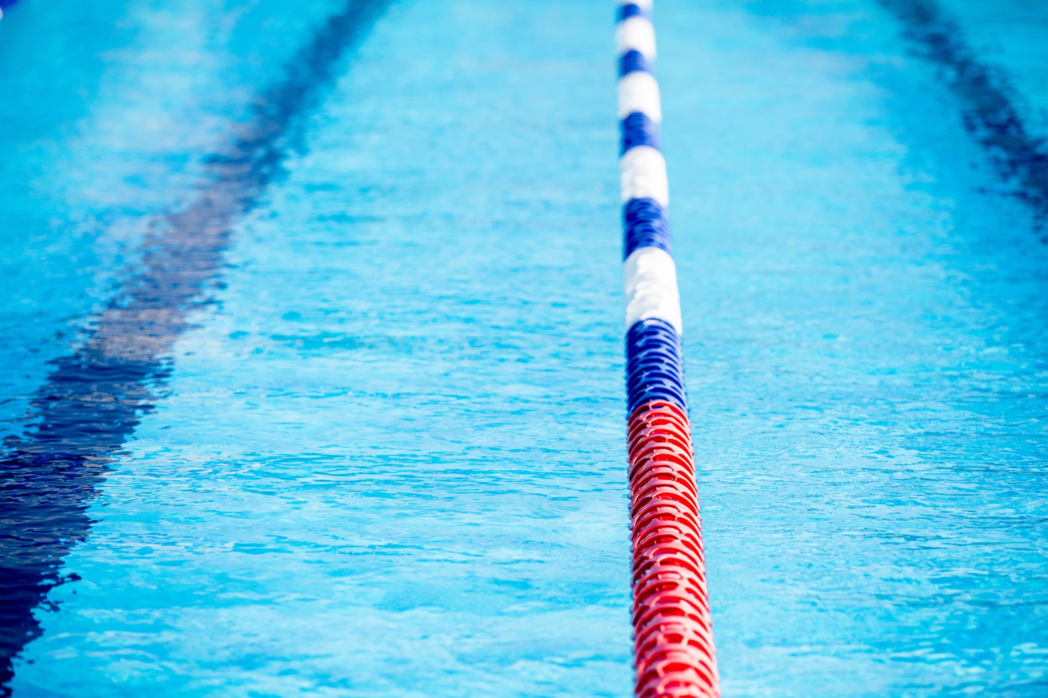 A swimming pool lane marked by blue, red, white dividers.