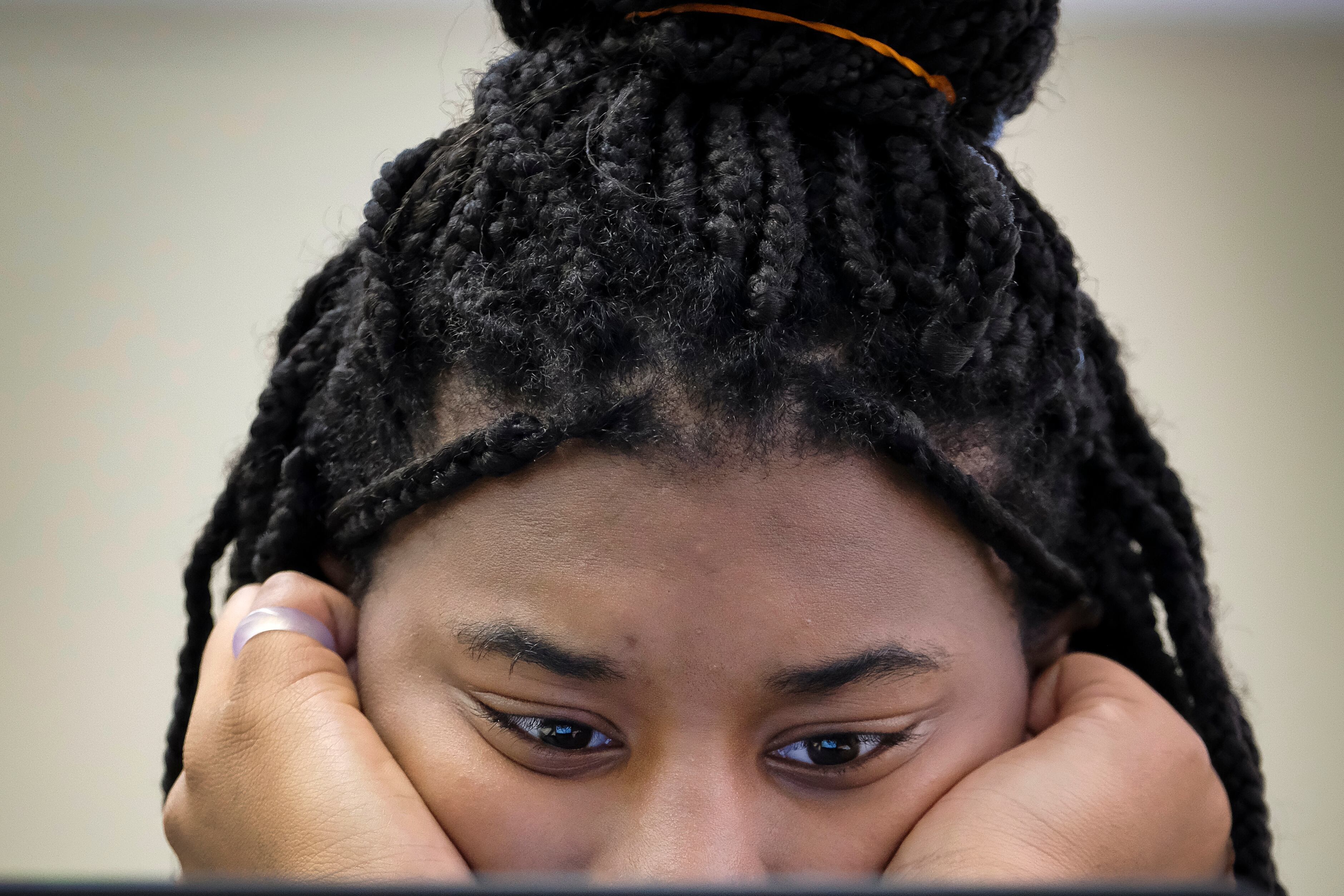 A student in a classroom uses a laptop computer.