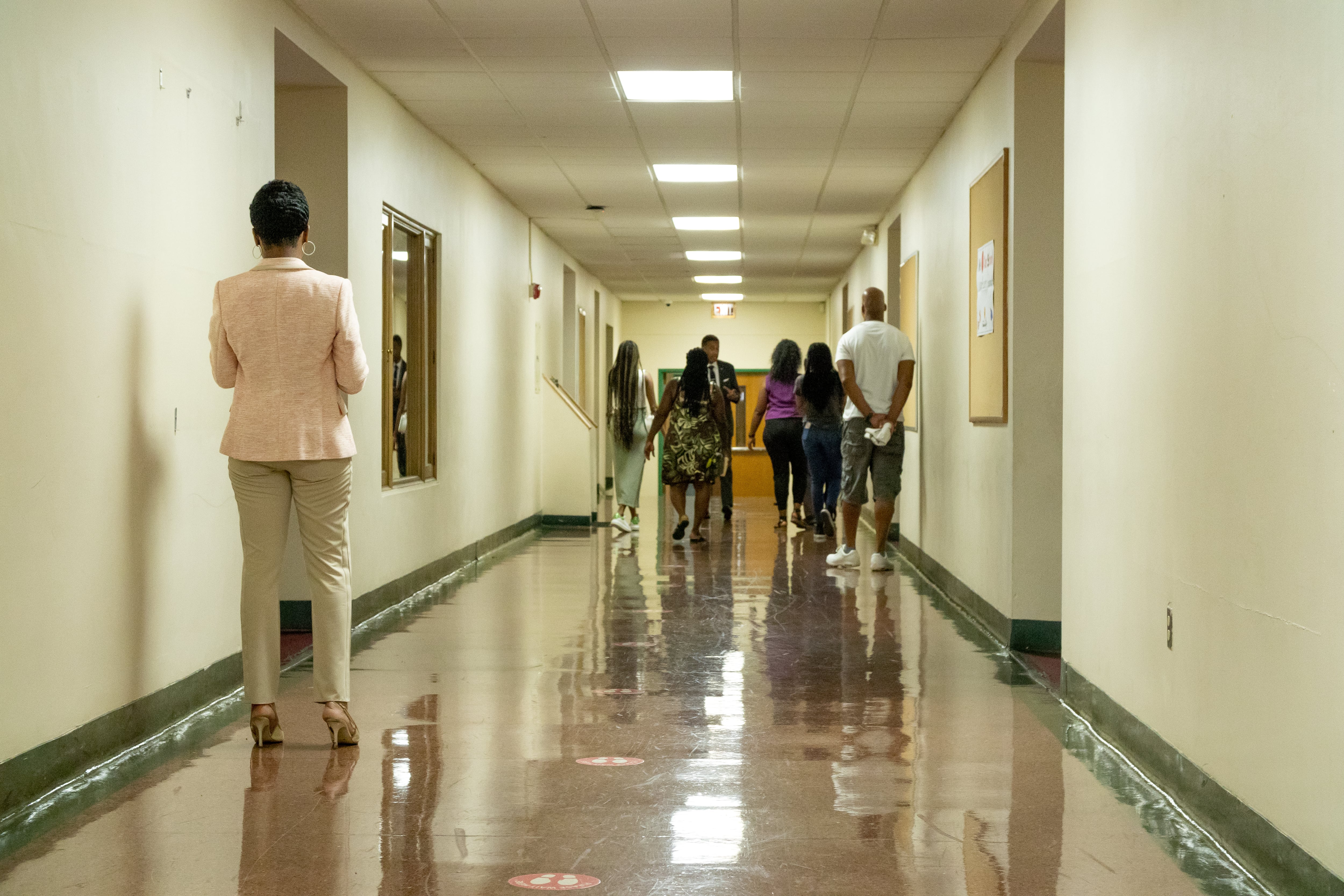 A group of people walk down the hallway of a building that will house Life Remodeled’s community hub in the Denby High School neighborhood.