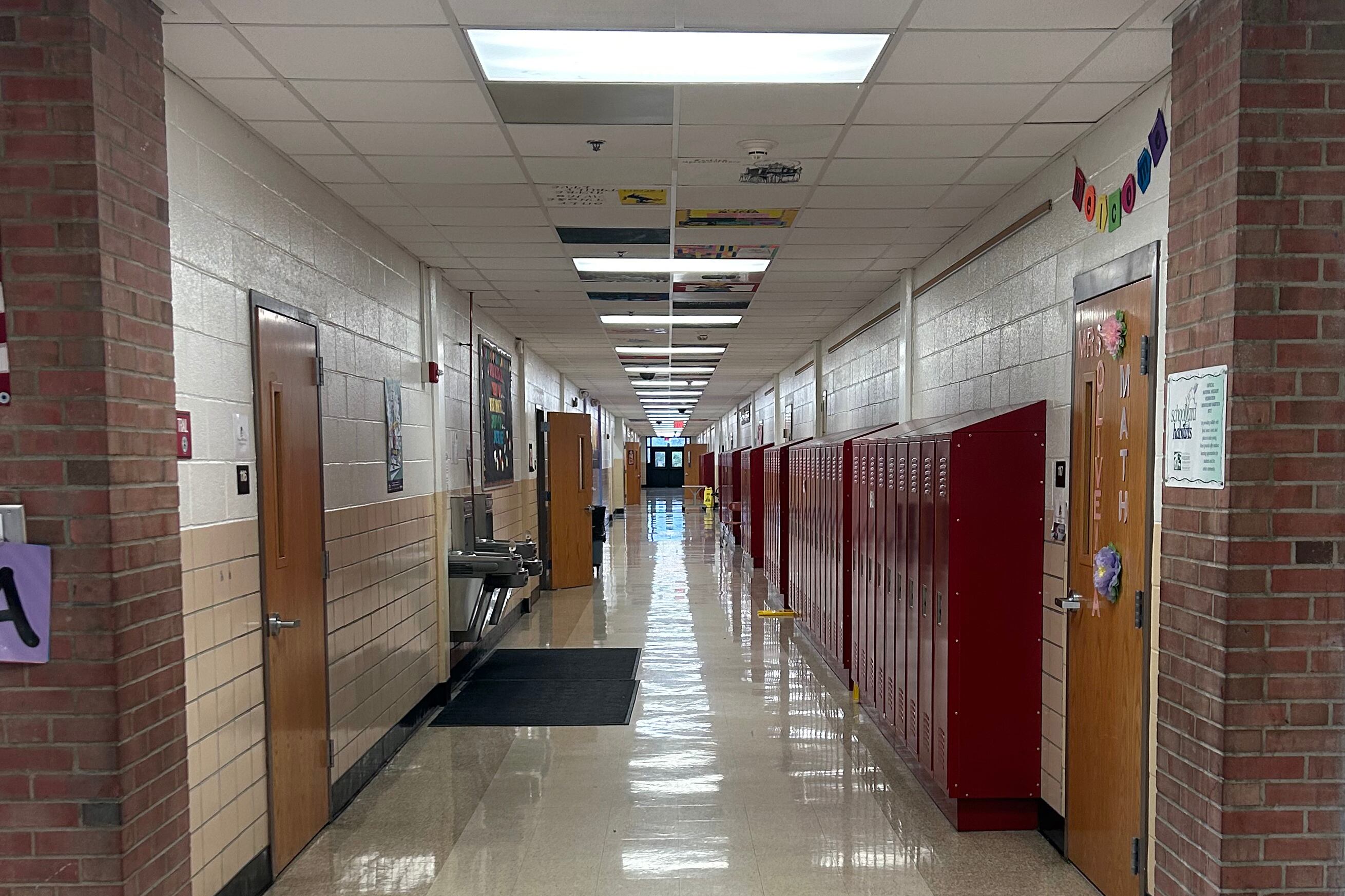 A picture of a school hallway, with classroom doors on either side of the hall.