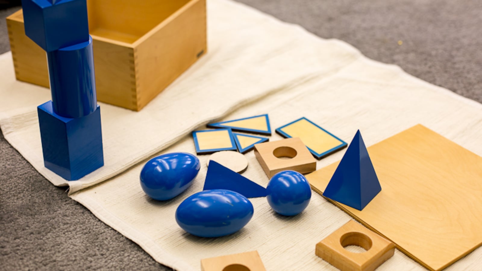 Montessori classrooms use specialized materials like wooden blocks to teach math and other concepts.