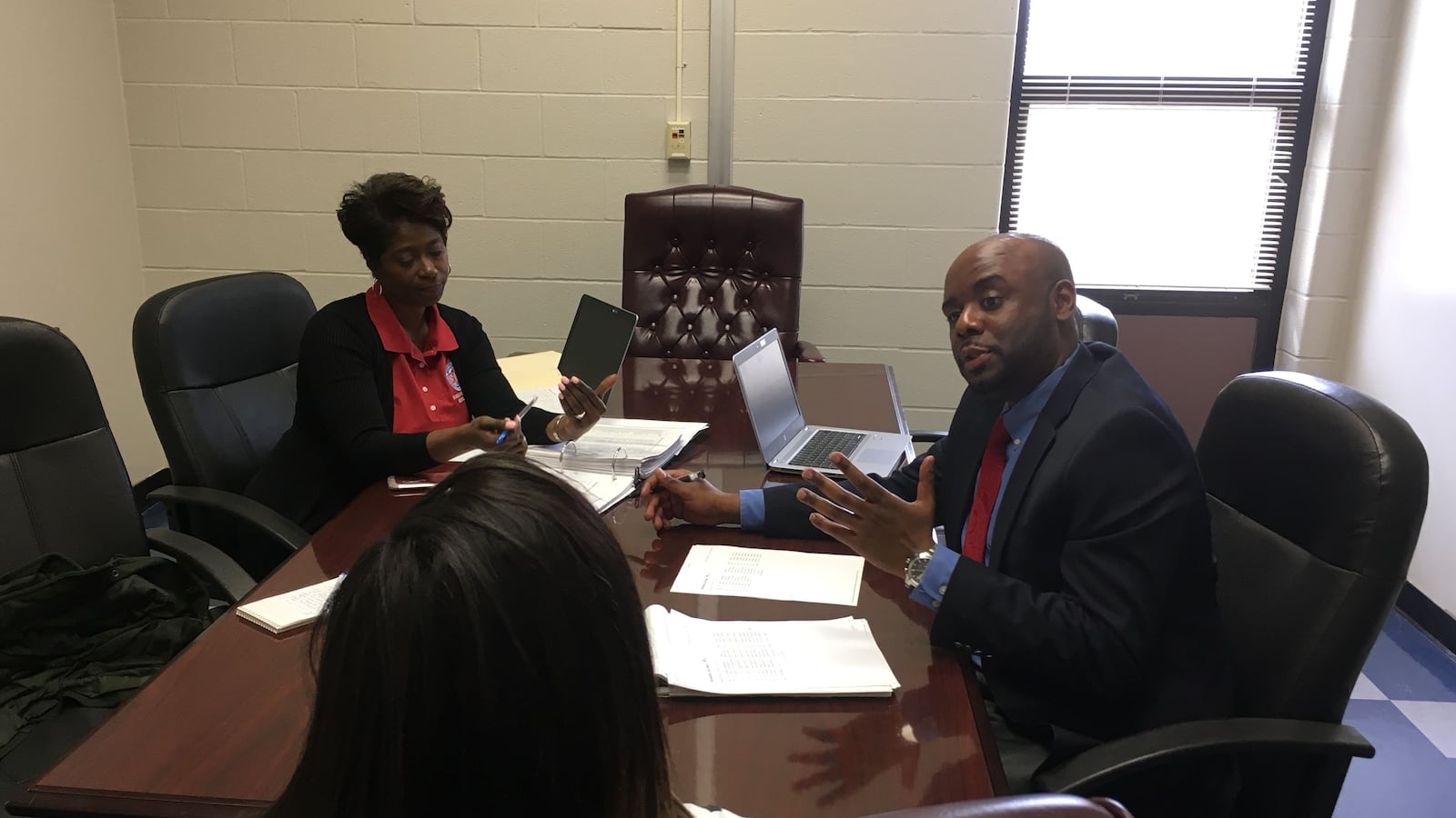 Behavior specialists Clarence Shaw and Inger Spikner speak with a student at Kirby High School in Memphis.