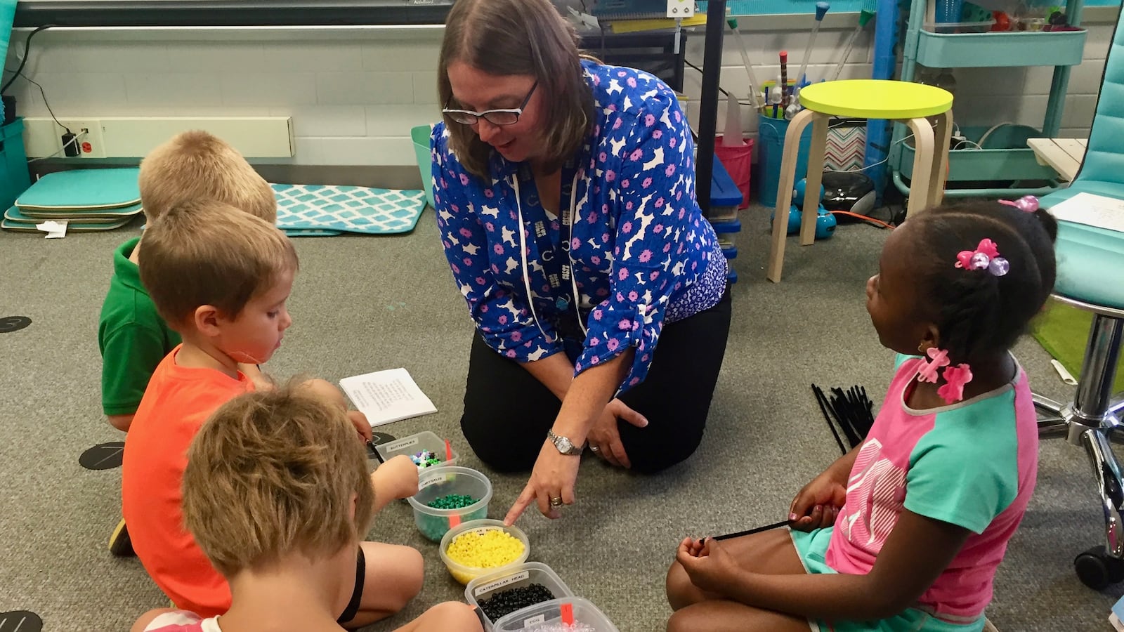 Kristin Poindexter helps her kindergarten students assemble butterfly bracelets in her science class at Spring Mill Elementary School in Washington Township.