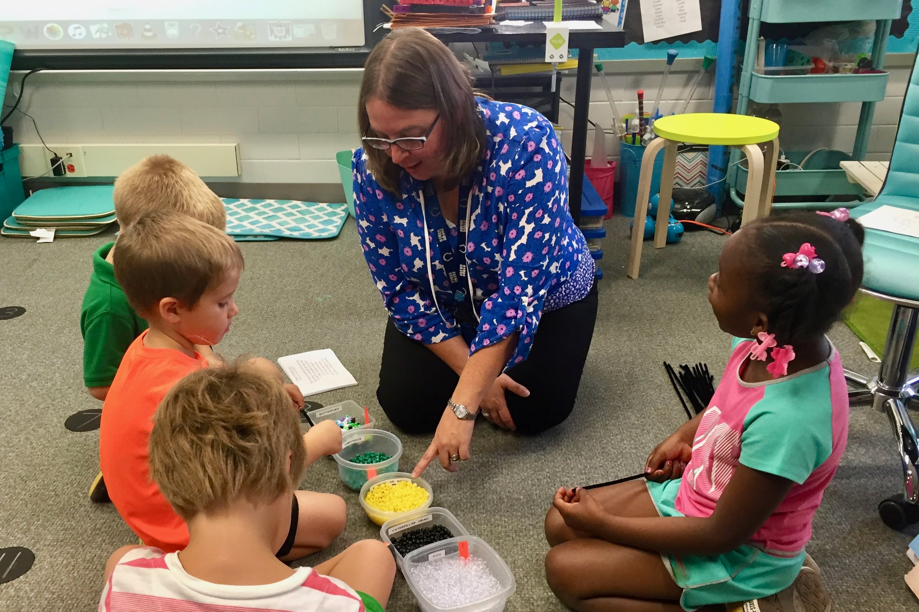 Kristin Poindexter helps her kindergarten students assemble butterfly bracelets in her science class at Spring Mill Elementary School in Washington Township.