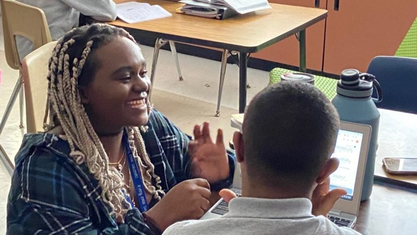 Rosine Niyoyishura, a teaching apprentice in the EdConnect program, helps a student translate a song into sign language at Dr. Martin Luther King Jr. Early College in far northeast Denver.