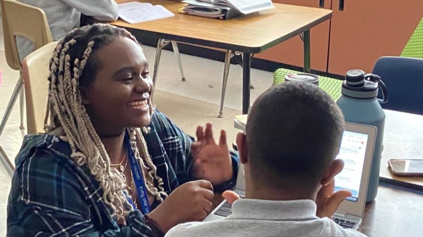 Rosine Niyoyishura, a teaching apprentice in the EdConnect program, helps a student translate a song into sign language at Dr. Martin Luther King Jr. Early College in far northeast Denver.