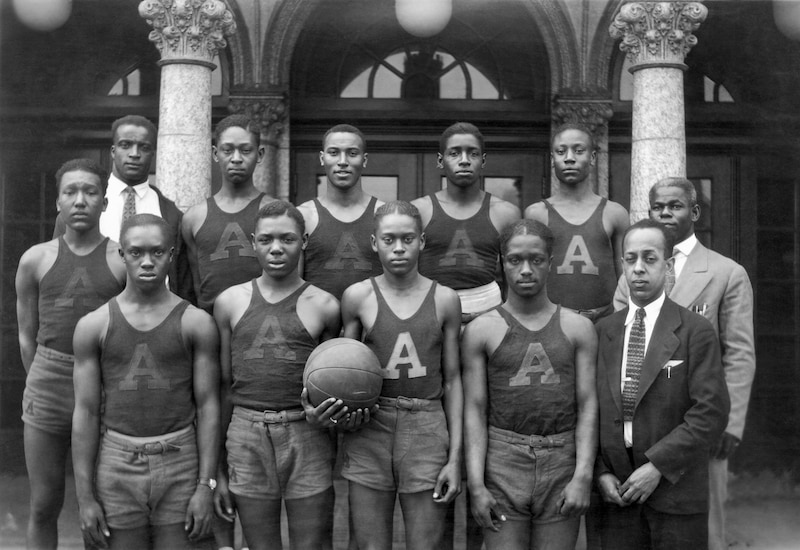 A group of teenagers stand with a basketball.