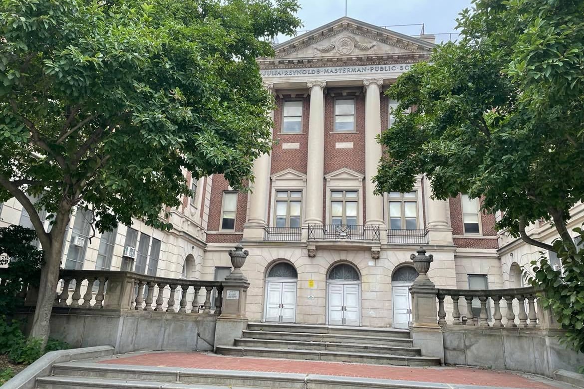 An exterior shot of Julia R. Masterman High School on Spring Garden Street, with trees in the foreground.
