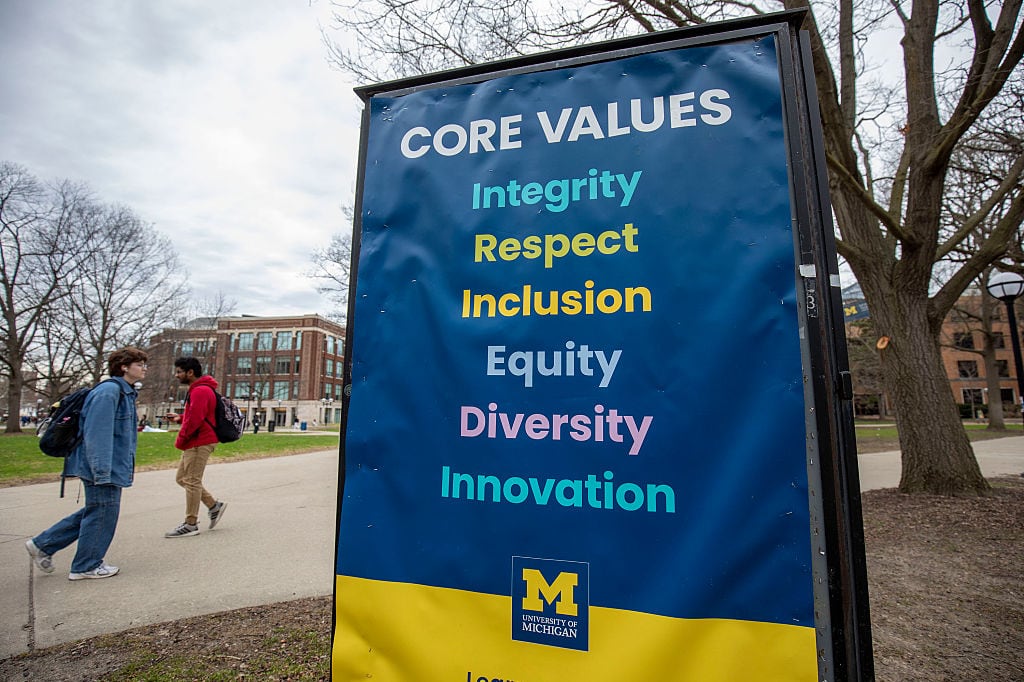 A blue and yellow banner on a university campus reads: Core Values, Integrity, Respect, Inclusion, Equity, Diversity, Innovation.