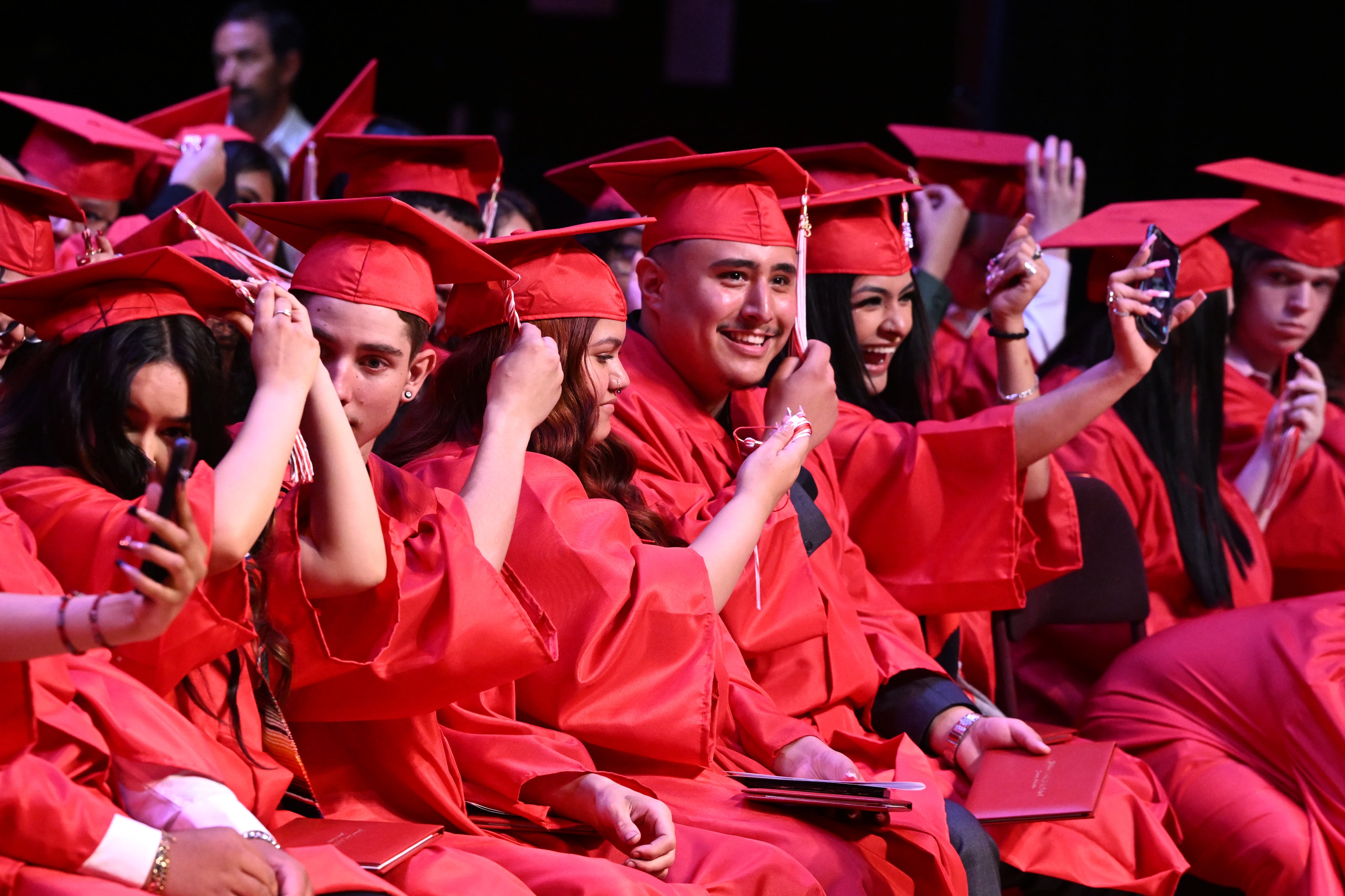 High school graduates in red caps and gowns.