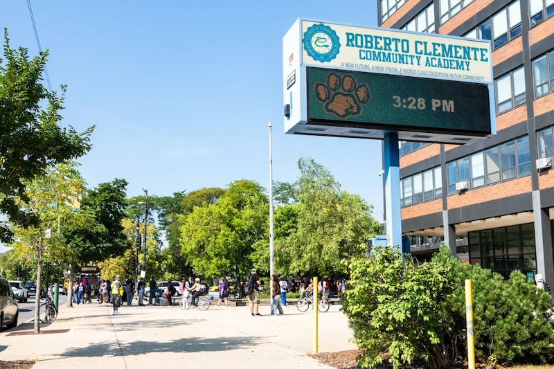 A school billboard stands in front of a building.