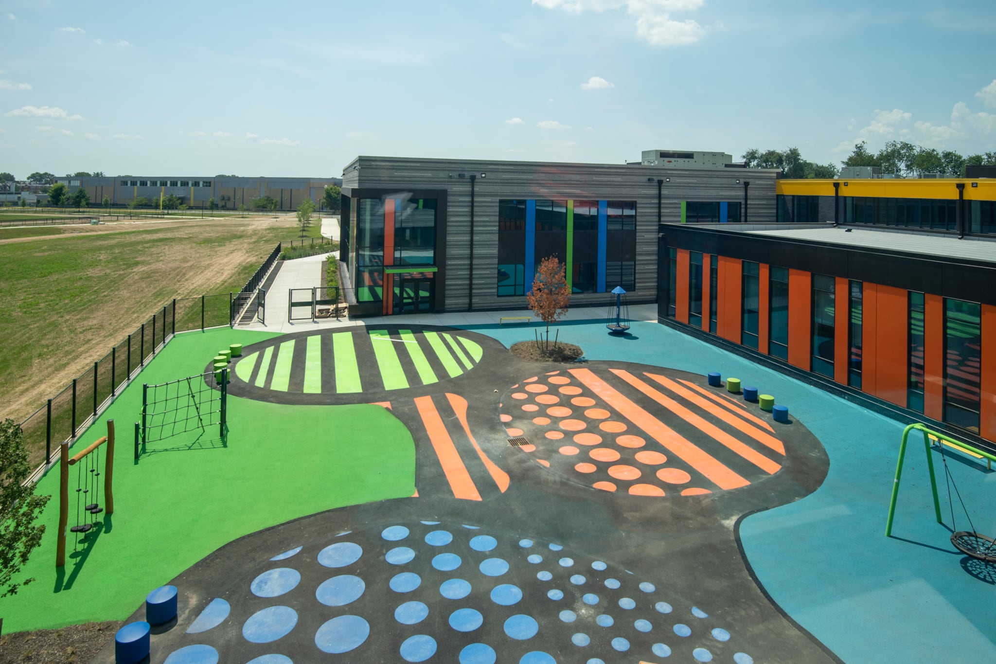 The courtyard of the new Northeast Community Propel Academy has bright green, orange, and blue floors and recess equipment.