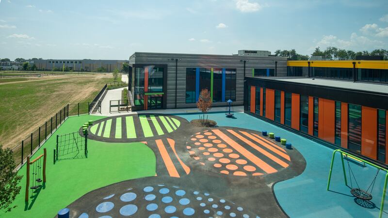 The courtyard of the new Northeast Community Propel Academy has bright green, orange, and blue floors and recess equipment.