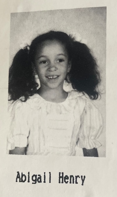 Yearbook photo of a young girl wearing pigtails and a white top.